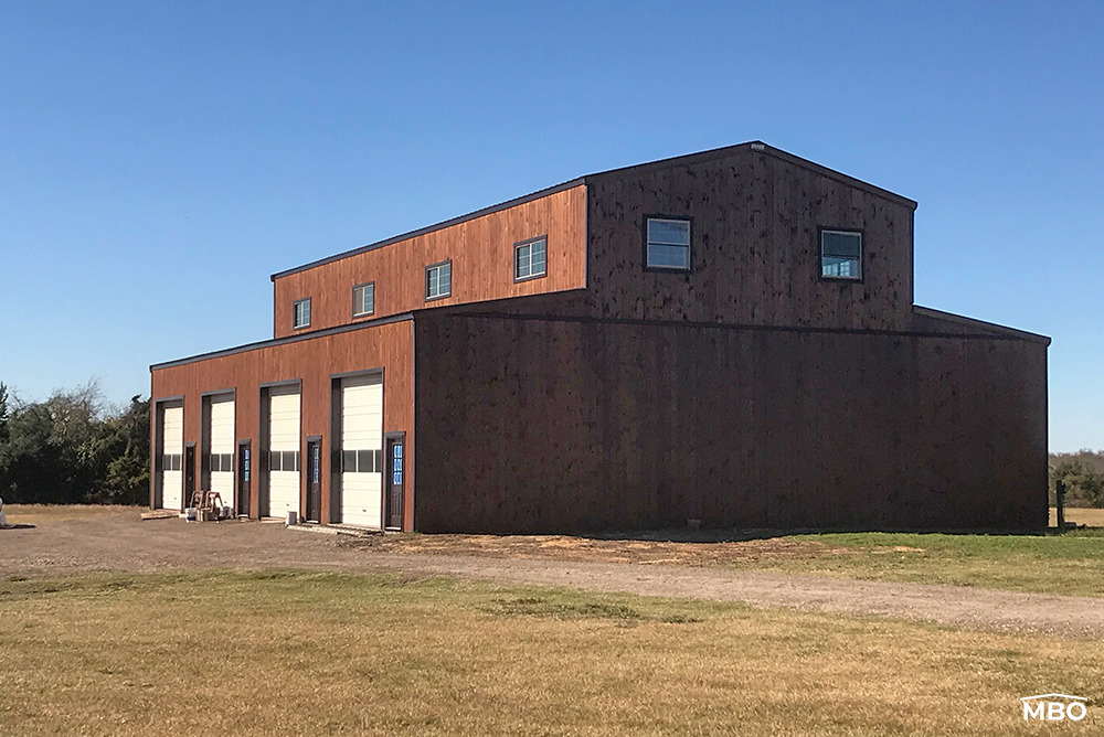 Prefabricated Barndominium Barndominium with a rustic style on a flat lot with grass and trees